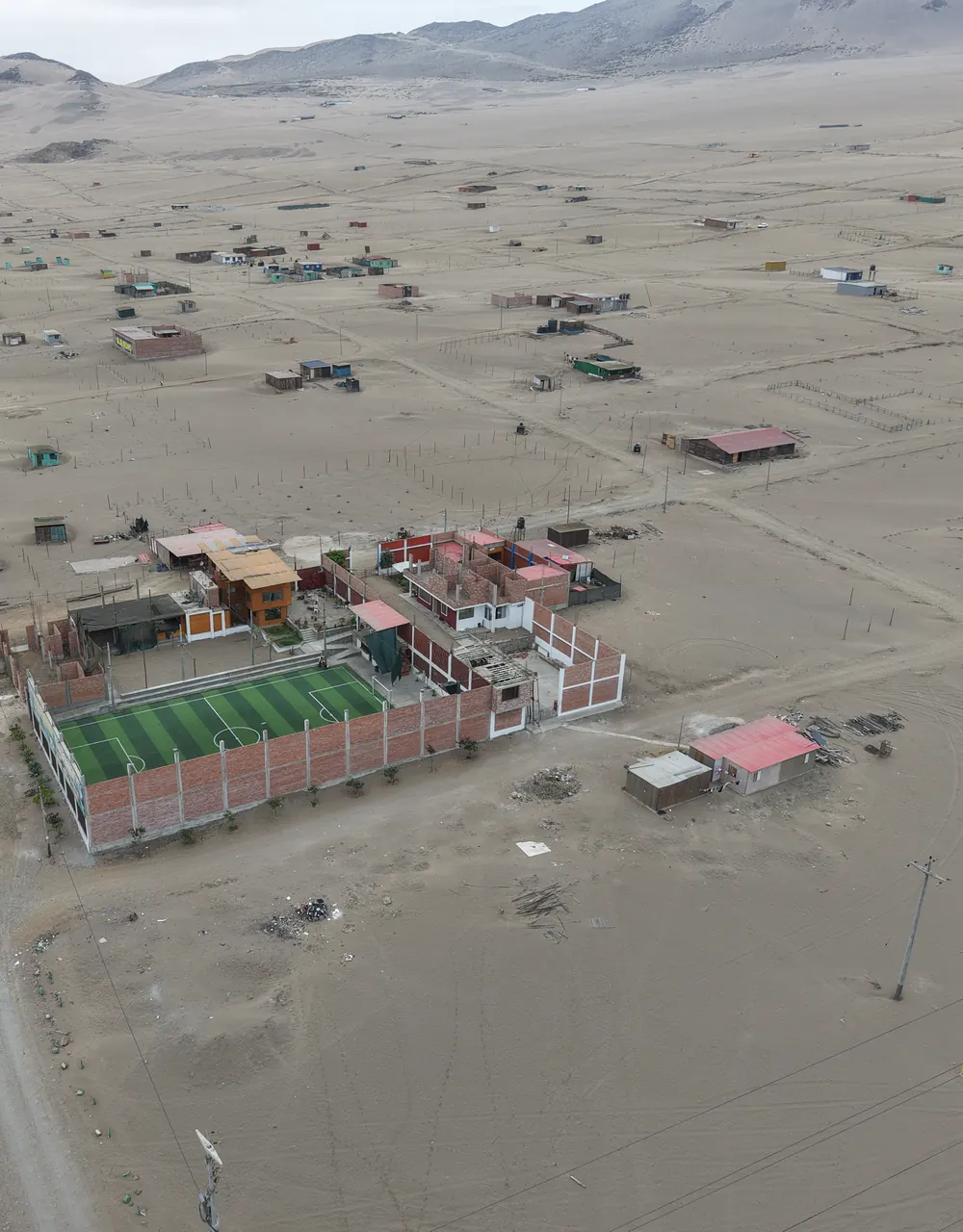 Viviendas construidas y una cancha deportiva dentro del proyecto, vistas desde el aire