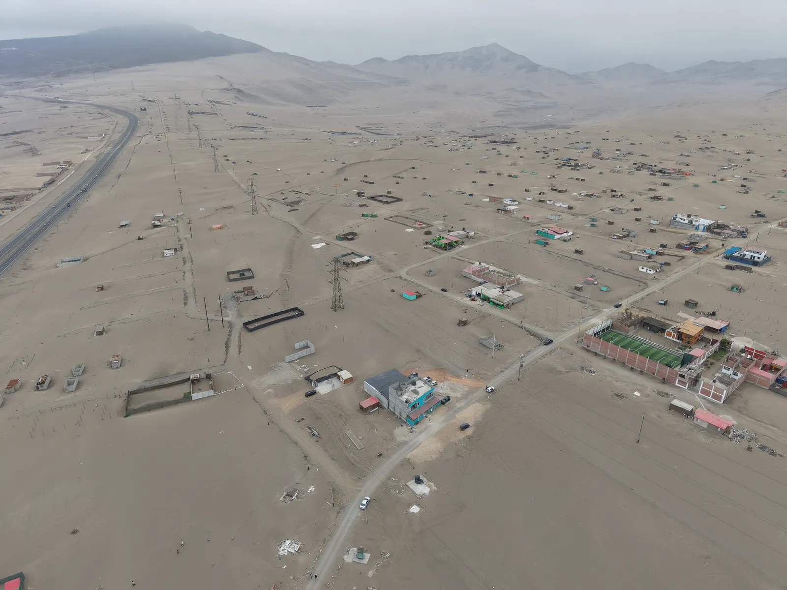 Vista aérea de Lomas de Cerro Verde: lotes delimitados, viviendas construidas y los cerros al fondo